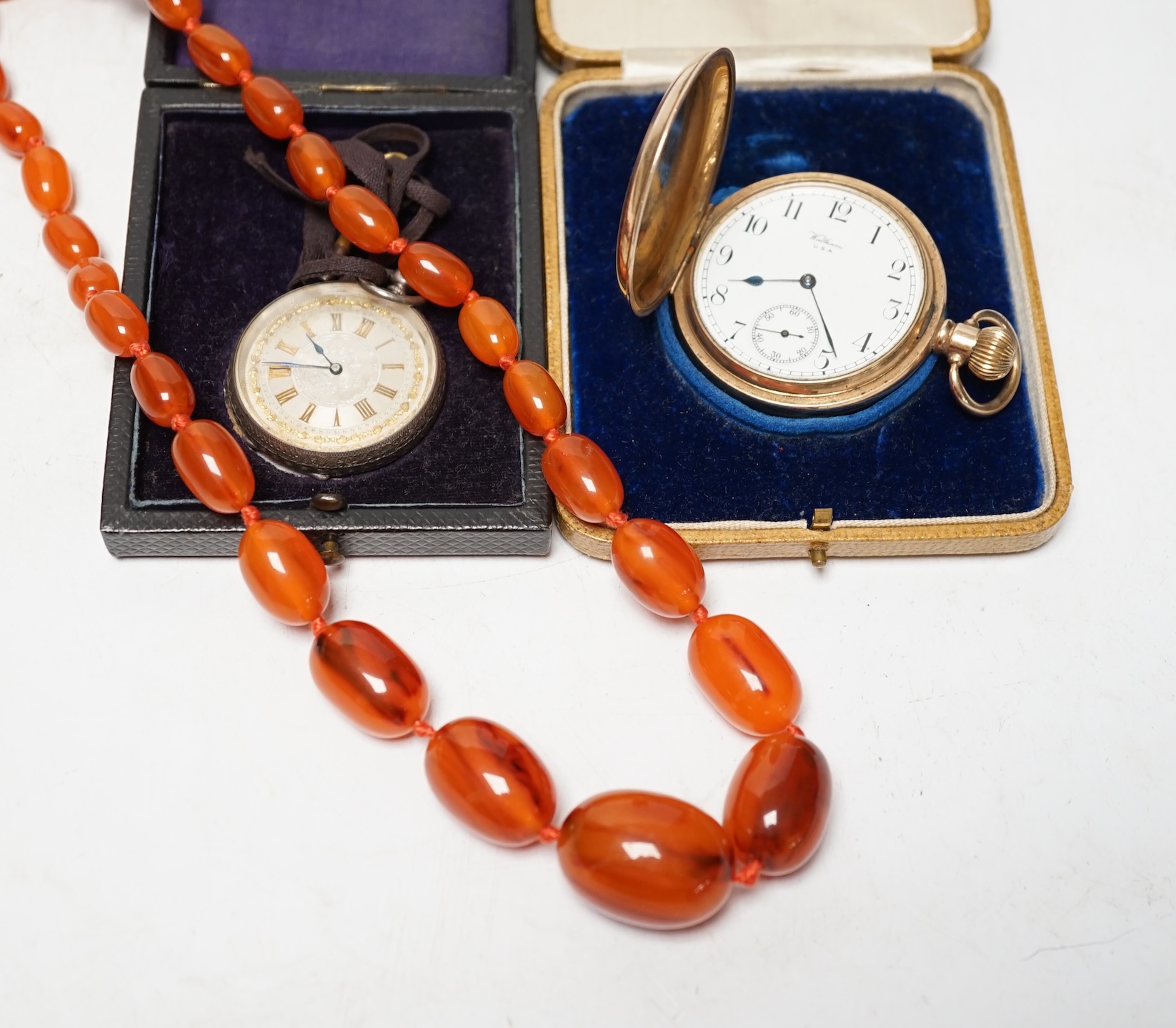 A Swiss 935 white metal fob watch, a gold played Waltham hunter pocket watch and a string of simulated amber beads. Condition - poor to fair